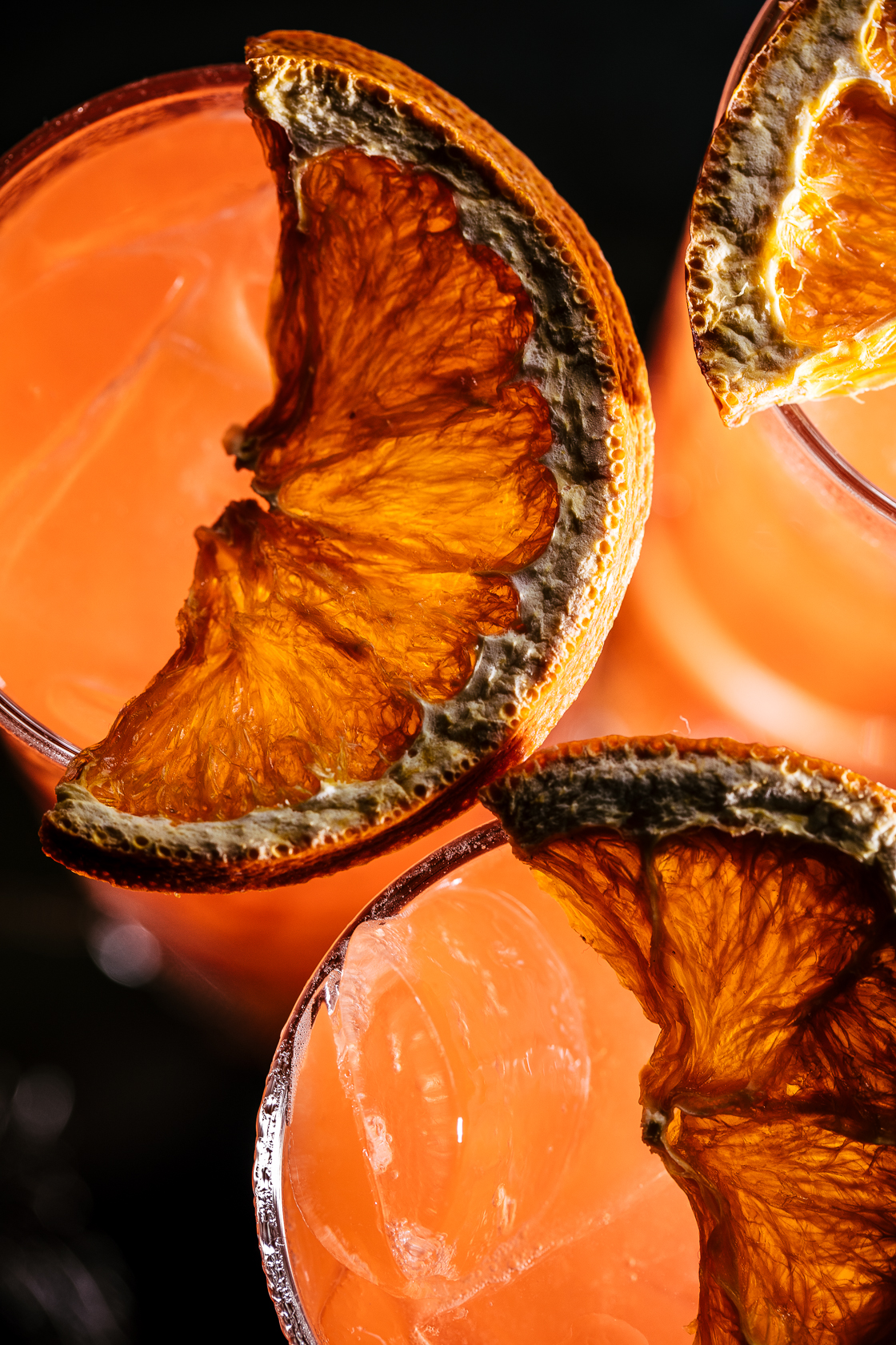 Close up of drink garnishes on top of orange drink