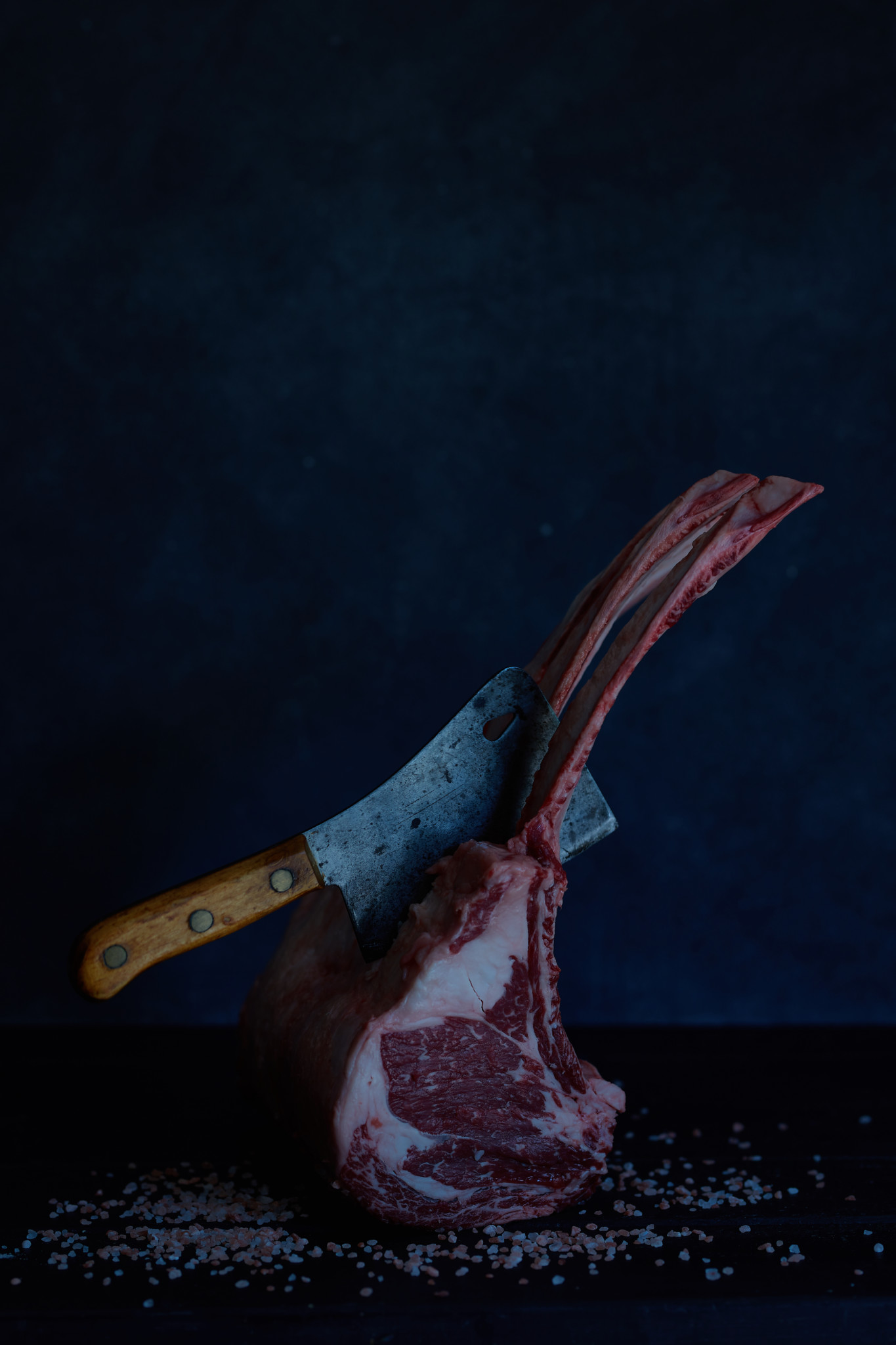 Large tomahawk steak with vintage knife stuck in ribs