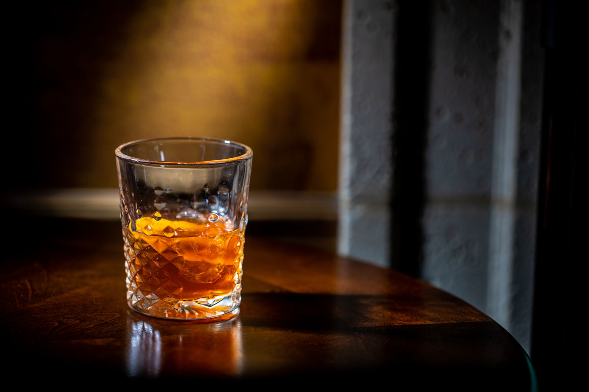 Elegant glass of bourbon with orange peel at Versace Mansion