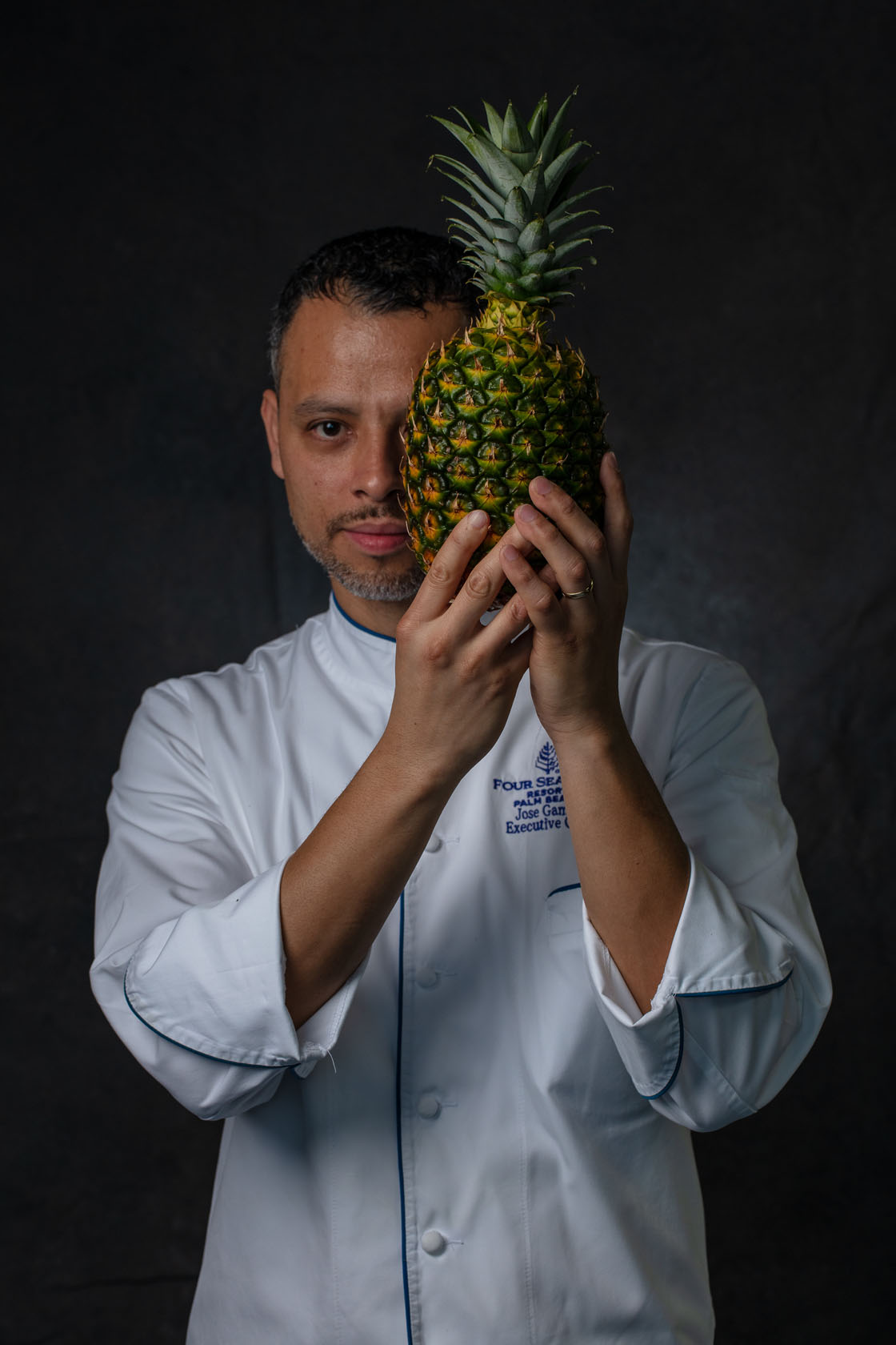 Chef at Four Seasons holds a pineapple up to his head