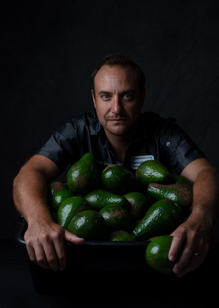 Intense photo of chef hugging a bowl full of avocados.