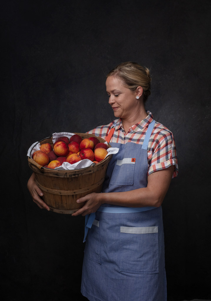 Beautiful chef Lindsay Autry holding a barrel of peaches