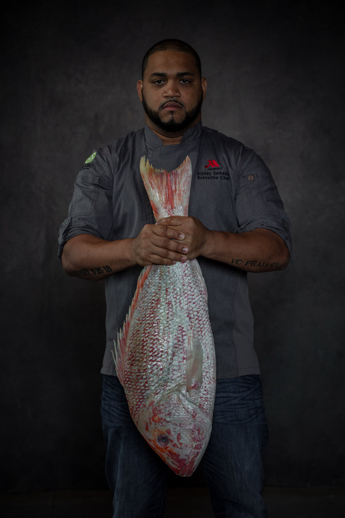 Mood portrait of chef holding giant fish by its tail