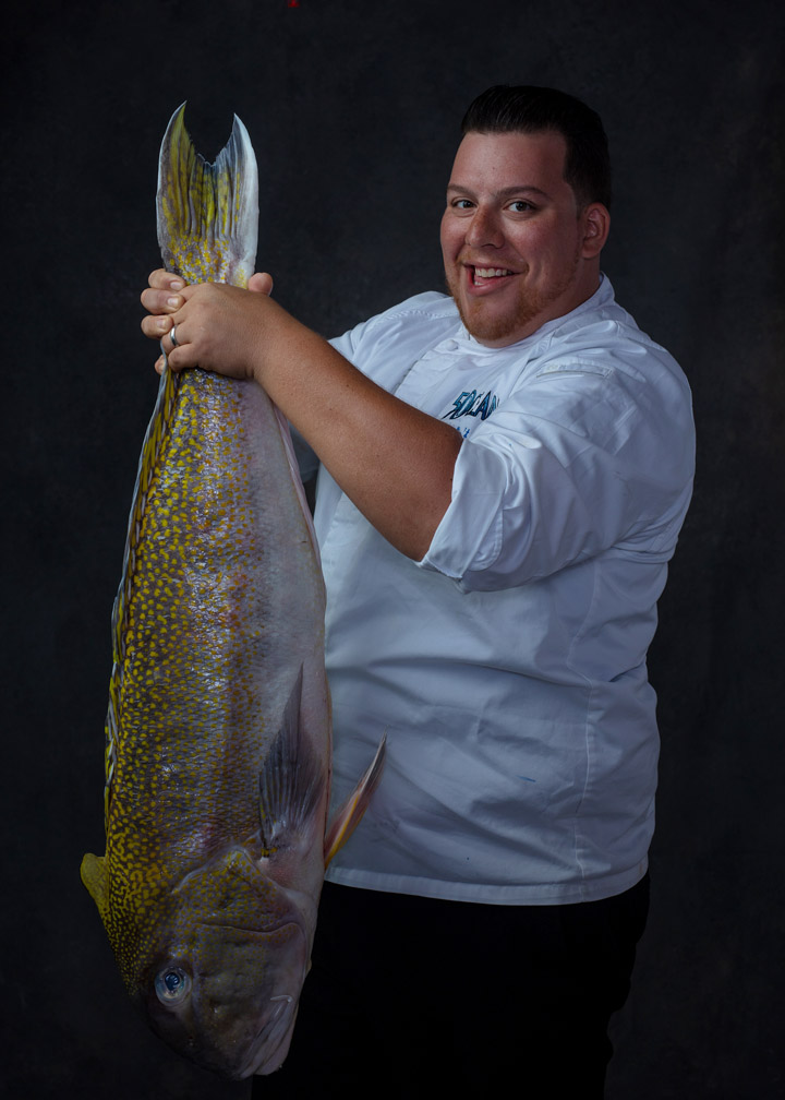 Chef holds giant fish by its tail