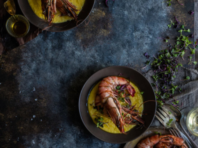large prawns in Corn Nage with basil oil in elegant food styling