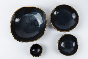 Handmade navy nesting bowls in a gold trim for props