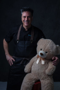 Chef with large teddy bear.