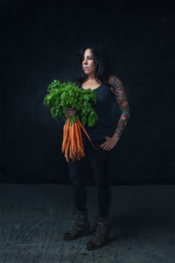 Top photo of chef with tattoos holding a bunch of carrots staring off camera
