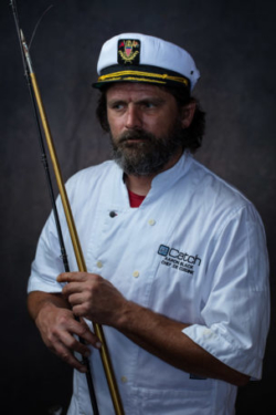 Beautiful portrait of chef with fishing rod and sailors hat