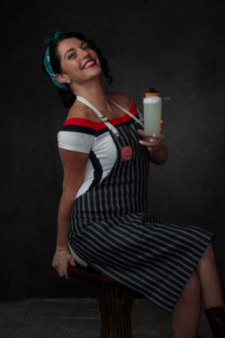 Flirty photo of mixologist coyly holding a cocktail