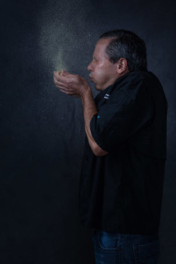 Executive Chef blows flour into the air in creative chef portraiture