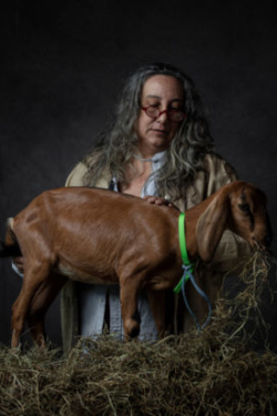 Moody lighting with farmer and baby goat eating hay