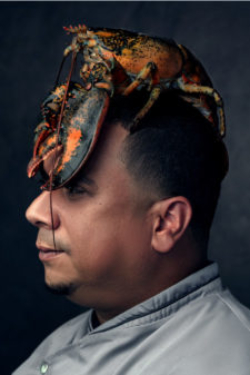 Chef with a huge lobster sitting on his head