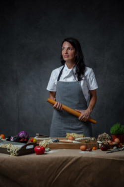 Talented Italian chef holds a rolling pin as she makes fresh pasta from scratch