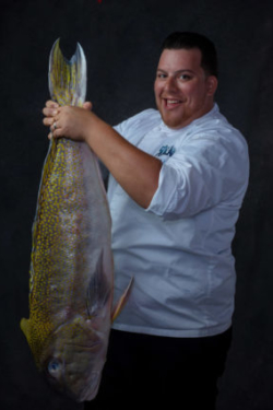 Chef holds giant fish by its tail