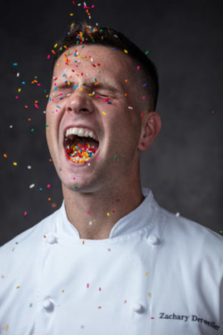Pastry chef catches sprinkles in his mouth as they fall in the photo